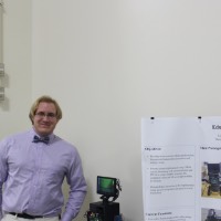 A presenter standing next to an educational robot.